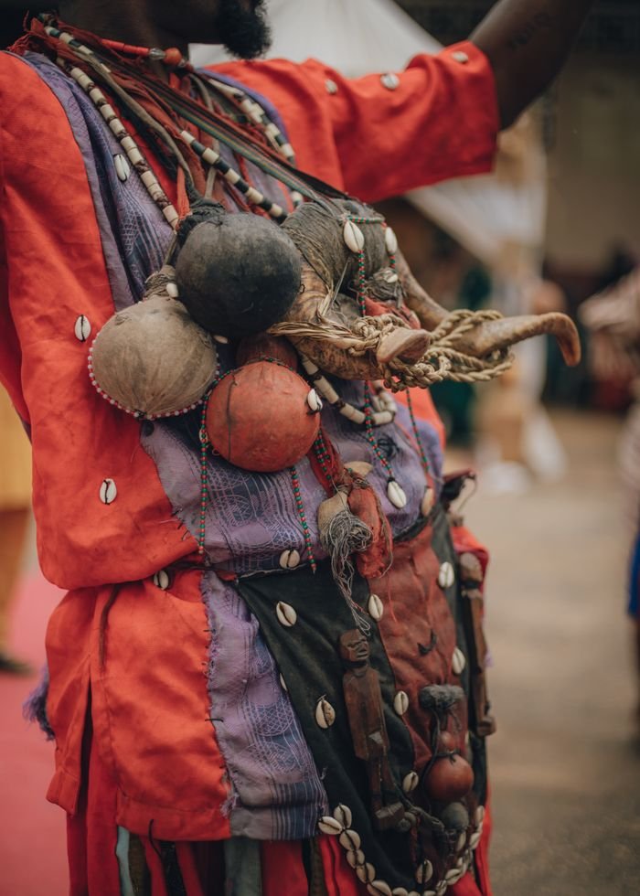 About Close-up of colorful African traditional clothing adorned with beads and decorative items.