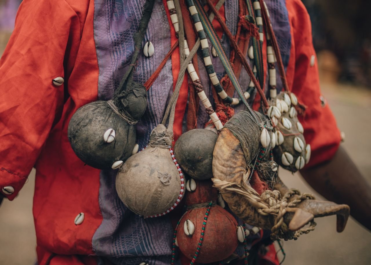 The Art of Drawing Readers In: Your attractive post title goes here Close-up of traditional African attire adorned with beads, shells, and gourds.